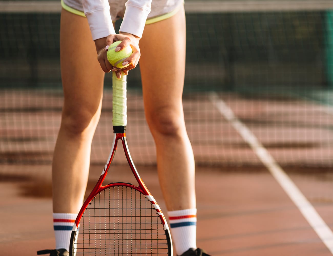 Tennis player holding racket and ball on a clay court
